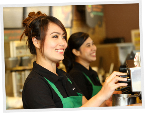 Smiling Starbucks baristas making espresso